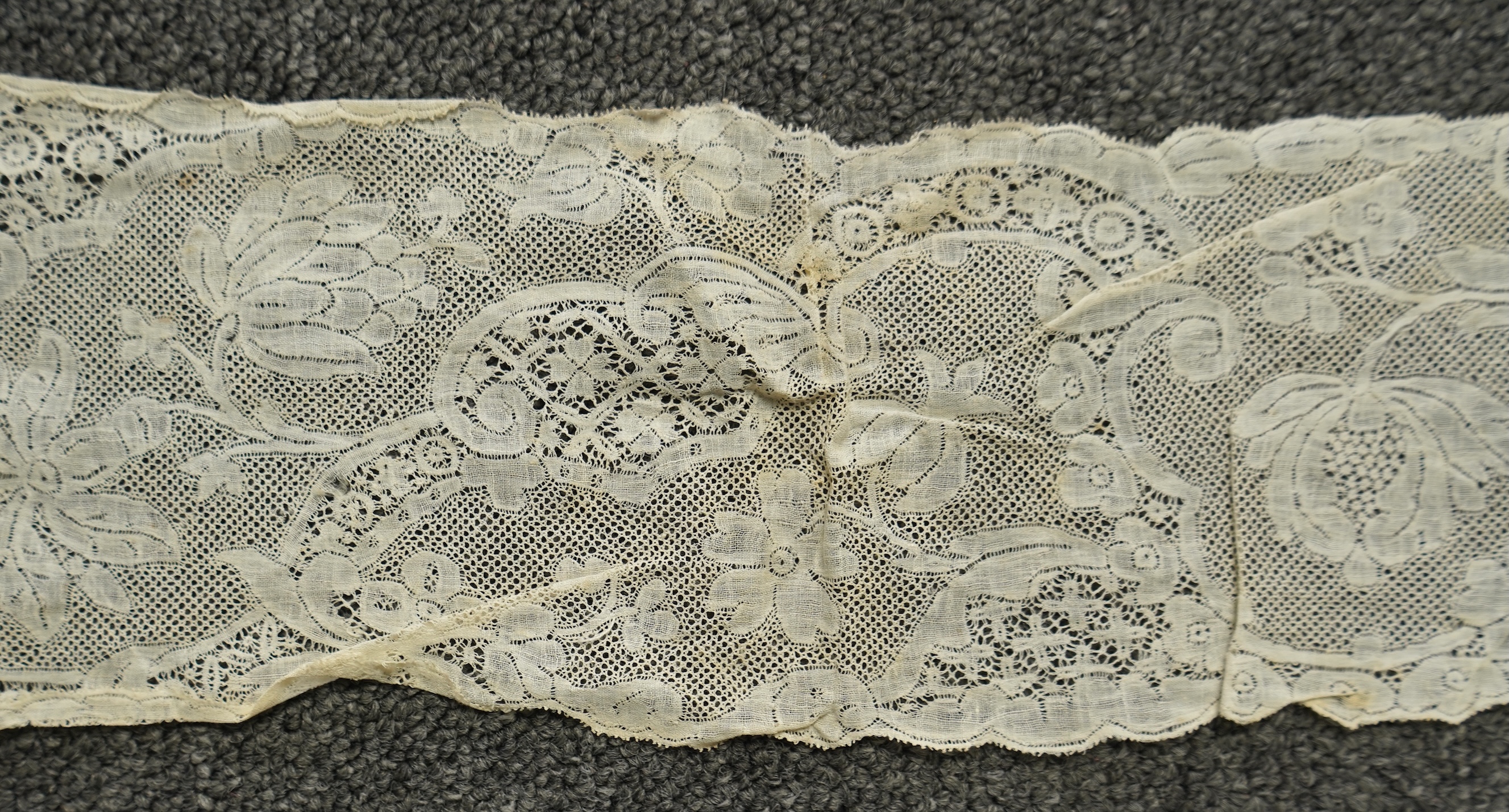 A collection of 18th century needle and bobbin lace. Including an 18th century wide pair of joined Valenciennes lace lappets, a similar 18th century cap back, an ornately worked Point de Alencon cap crown and another sim